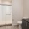 Large well lit bathroom with large mirror and brown cabinets 