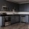 Spacious and well lit kitchen with wood floors and stainless steel appliances. 
