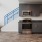 Spacious and well lit kitchen with wood floors and stainless steel appliances. 