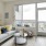 Spacious and well lit living room with wood floors and an open floor plan with access to the kitchen.