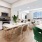 Spacious and well lit kitchen with wood floors and stainless steel appliances. 