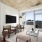 Spacious and well lit living room with wood floors and an open floor plan with access to the kitchen.