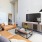 Spacious and well lit living room with wood floors and an open floor plan with access to the kitchen.