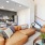 Spacious and well lit living room with wood floors and an open floor plan with access to the kitchen.